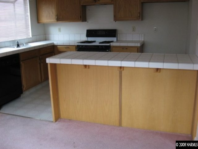 5950 Walnut Creek Road Reno, NV 89523 - Photo 3 of 7 a kitchen with a sink a stove top oven and cabinetry