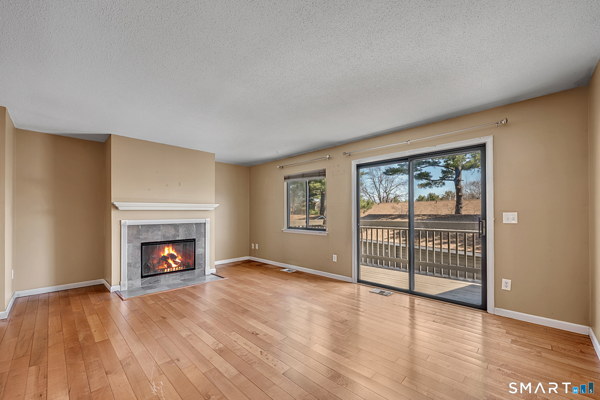160 Brittany Farms Road, Unit F New Britain, CT 06053 - Photo 8 of 35 an empty room with wooden floor fireplace and windows