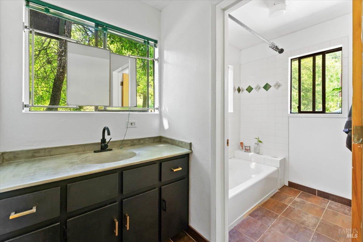 125 Cedar Gulch Road Hayfork, CA 96041 - Photo 42 of 57 a bathroom with a granite countertop sink a bathtub and window