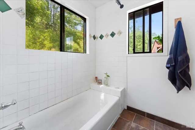 an empty room with window and a ceiling fan