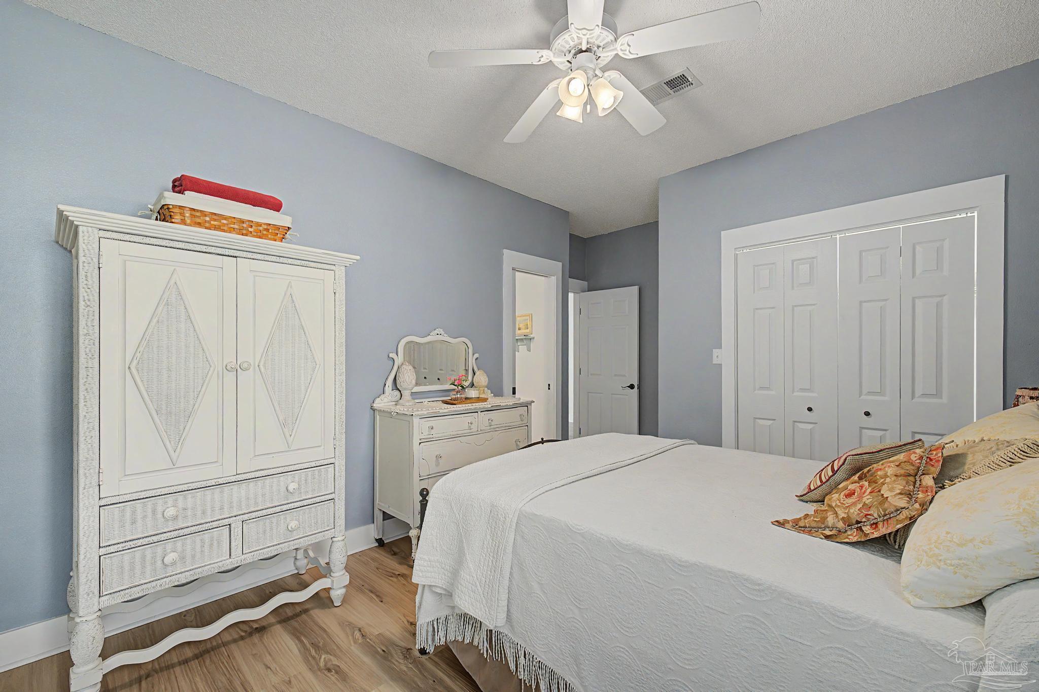 2005 Riviera Lane South Navarre, FL 32566 - Photo 33 of 70 a bedroom with a large bed and a chandelier