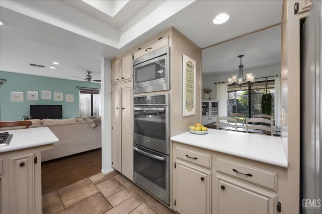 a kitchen with stainless steel appliances a table chairs and a refrigerator