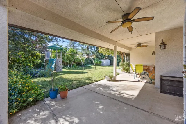 a patio with a table and chairs and potted plants