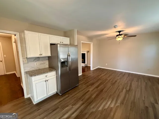 a kitchen with granite countertop a refrigerator and a stove top oven