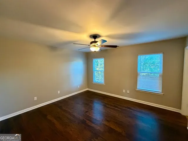 a view of a room with wooden floor and chandelier fan