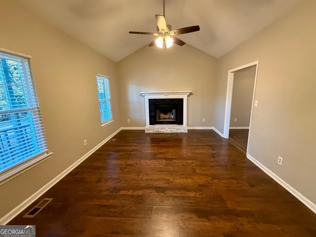 a view of an empty room with a fireplace and a window