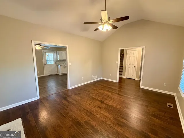 a view of an empty room with wooden floor