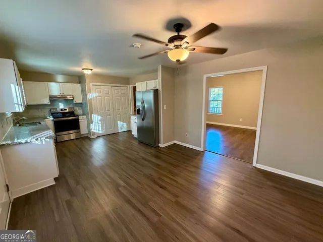 a view of a kitchen with wooden floor and a ceiling fan