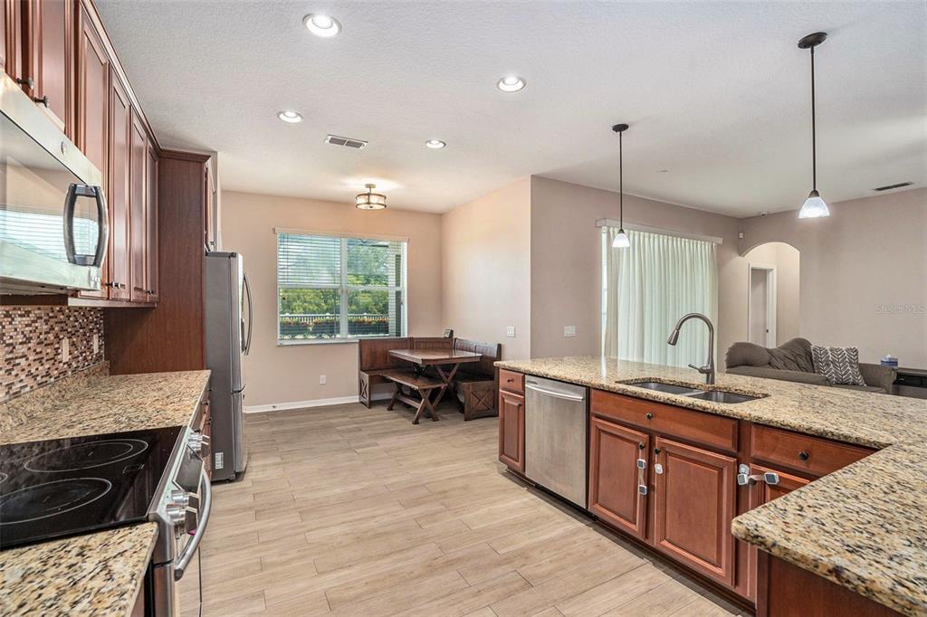 10737 Breaking Rocks Drive Tampa, FL 33647 - Photo 11 of 28 a kitchen with stainless steel appliances granite countertop sink stove and wooden floor