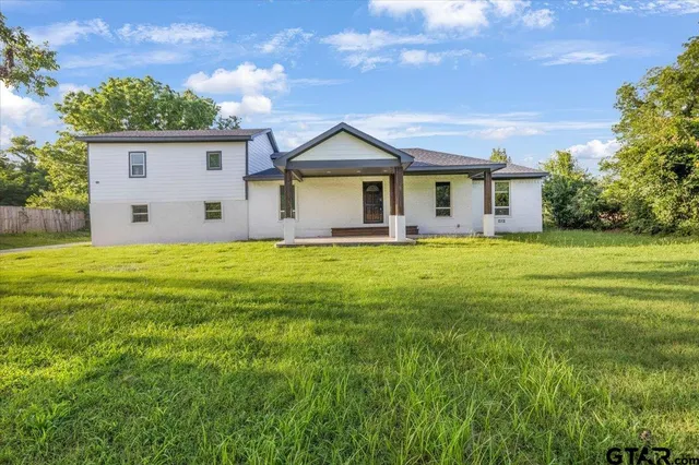 a view of a house with a yard and sitting area