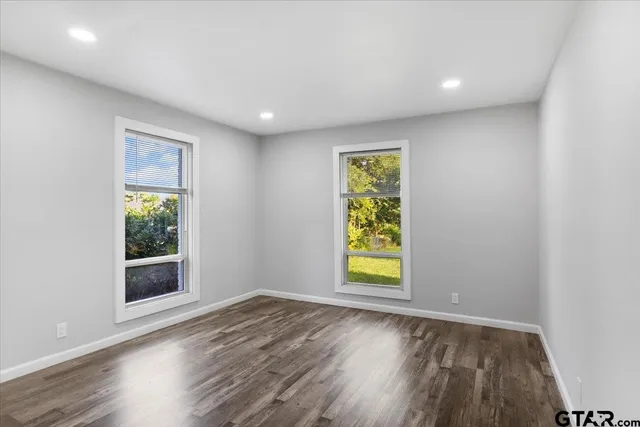 an empty room with a window and wooden floor