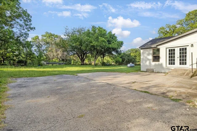 a view of a house with a yard and trees