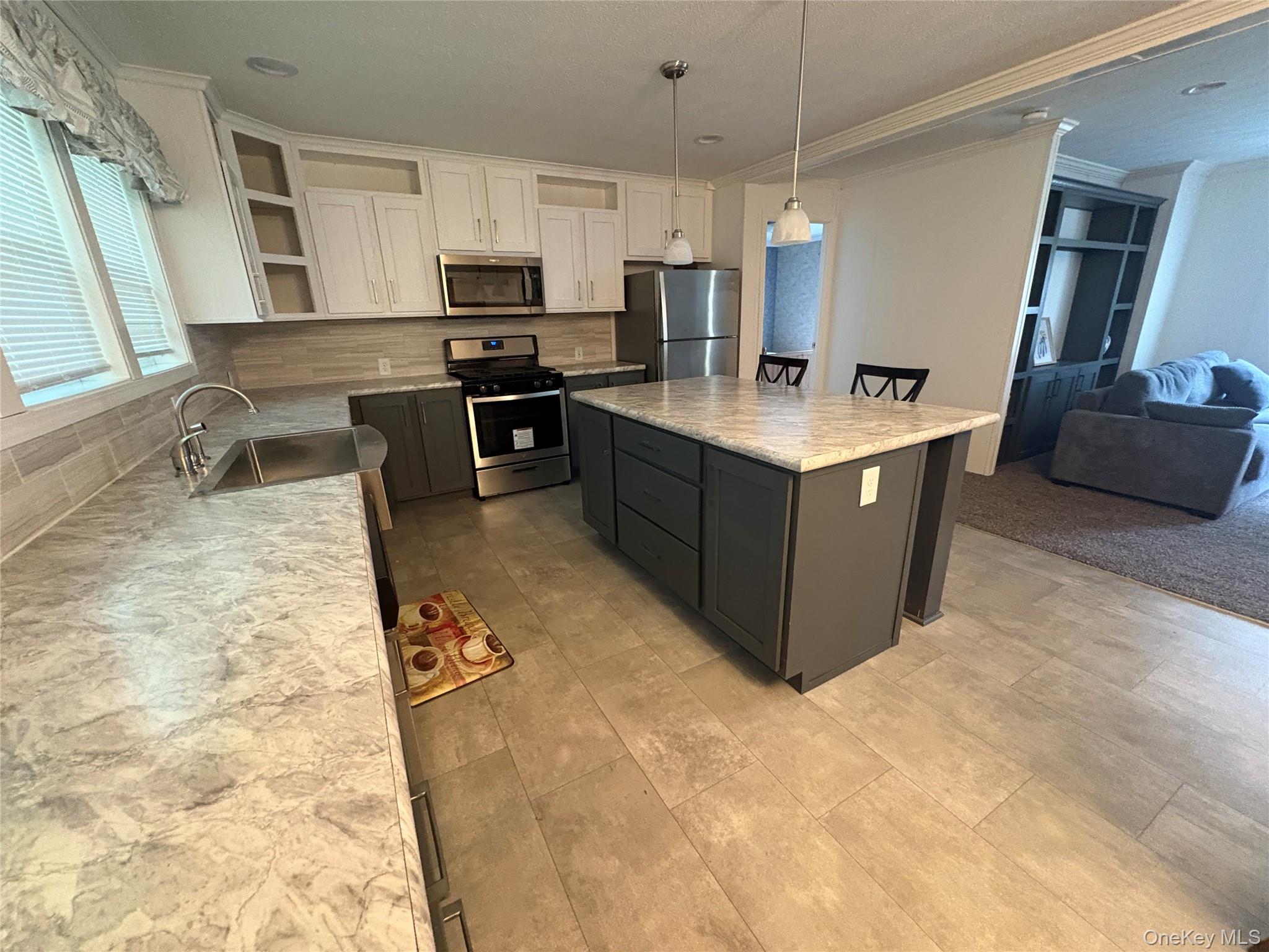 40 4th Street Godeffroy, NY 12729 - Photo 15 of 17 Modern kitchen with island seating, stainless steel appliances, and open layout.