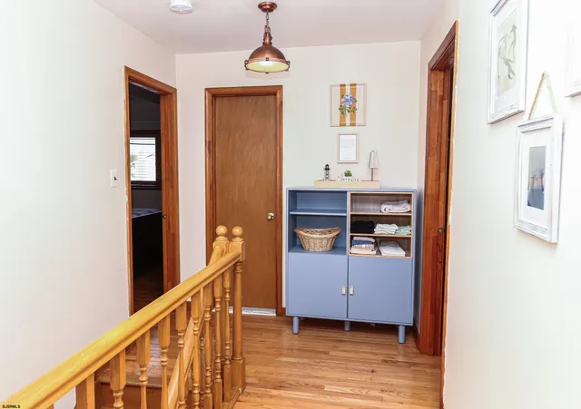a view of hallway with stairs and wooden floor
