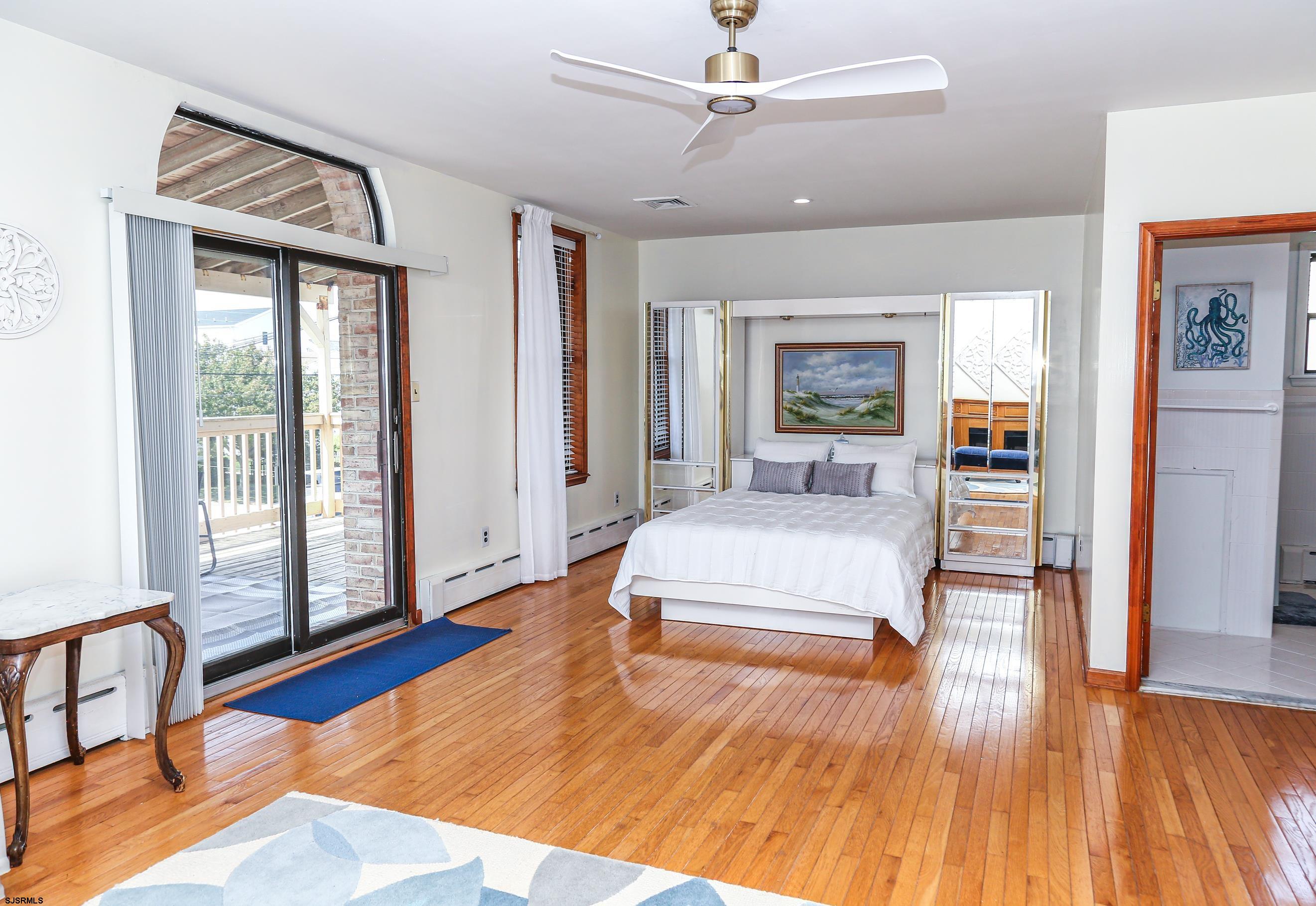 243 6th Street South Brigantine, NJ 08203 - Photo 14 of 28 a spacious bedroom with a large bed and a wooden floor