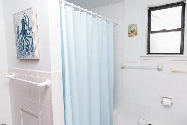 a bathroom with a shower curtain and a window