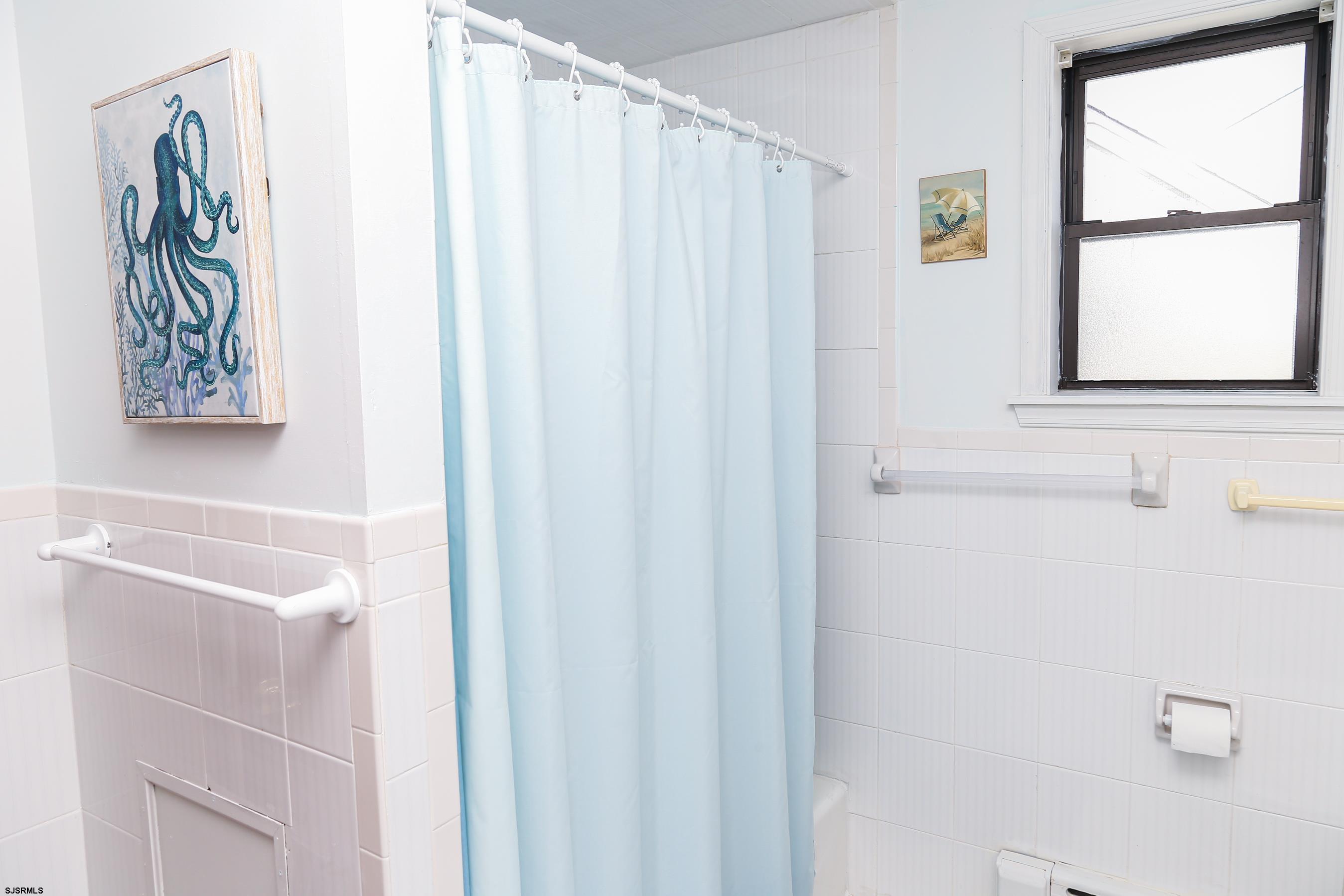 243 6th Street South Brigantine, NJ 08203 - Photo 23 of 28 a bathroom with a shower curtain and a window