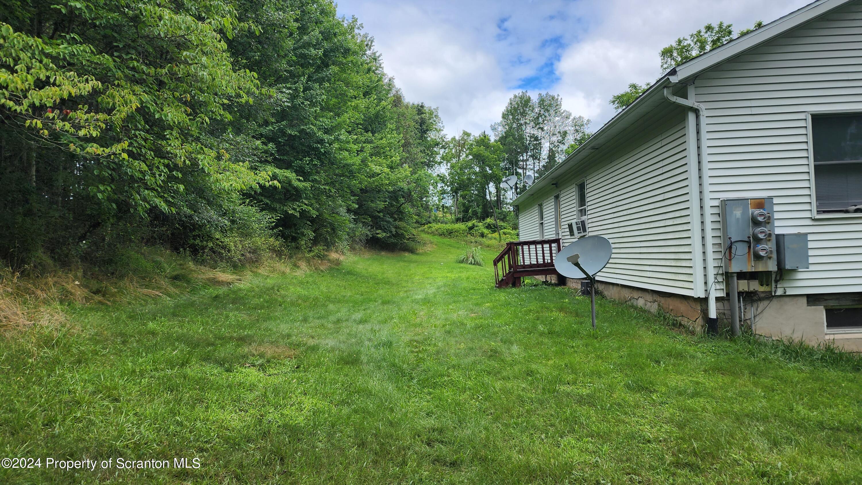 633 Meshopany Ridge Road Meshoppen, PA 18630 - Photo 29 of 41 a backyard of a house with plants and large tree