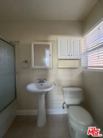 an empty room with a ceiling fan and windows