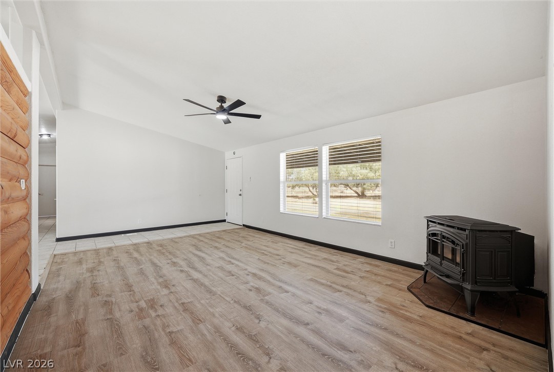 1531 West Harris Farm Road Pahrump, NV 89060 - Photo 19 of 37 A rustic-inspired great room features a cast iron fireplace and broad windows with outdoor views.