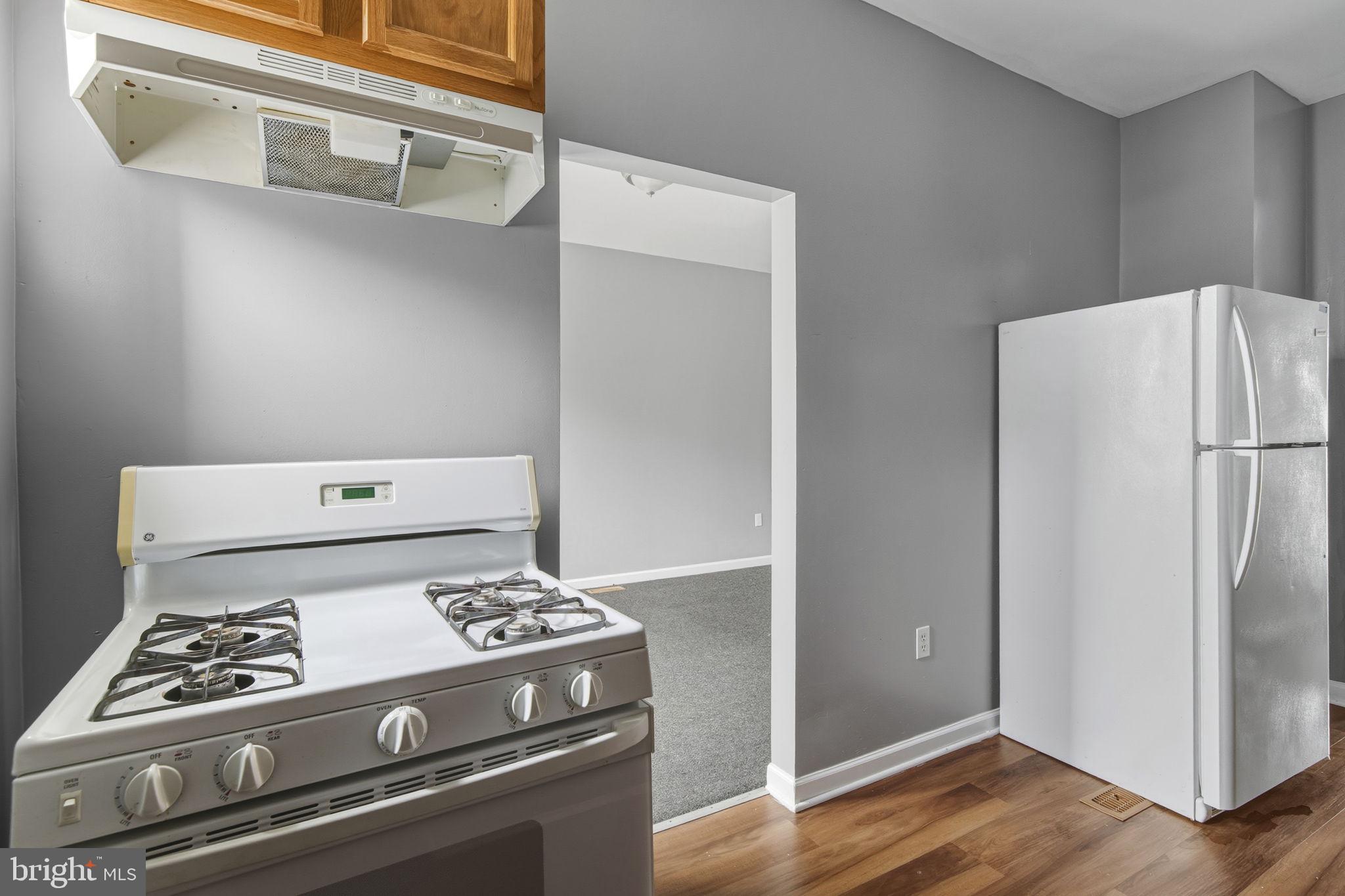 1209 North Dukeland Street Baltimore, MD 21216 - Photo 6 of 21 a kitchen with a stove and a refrigerator