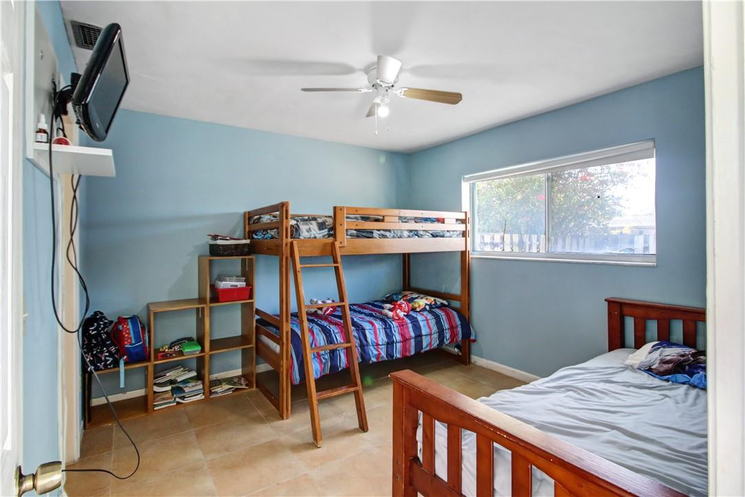 9157 Southwest 5th Street, Unit B Boca Raton, FL 33428 - Photo 14 of 21 a bedroom with a bed and a chandelier
