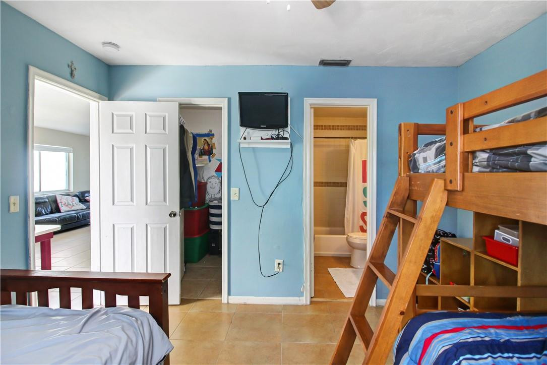 9157 Southwest 5th Street, Unit B Boca Raton, FL 33428 - Photo 15 of 21 a bedroom with a bed and a book shelf