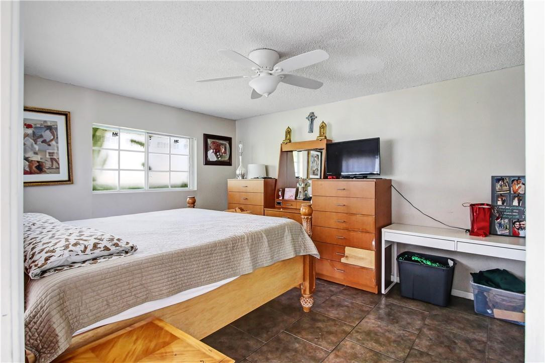 9157 Southwest 5th Street, Unit B Boca Raton, FL 33428 - Photo 10 of 21 a bed room with a bed and a chandelier