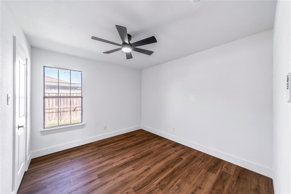 403 Melody Circle Kaufman, TX 75142 - Photo 17 of 25 an empty room with wooden floor fan and windows