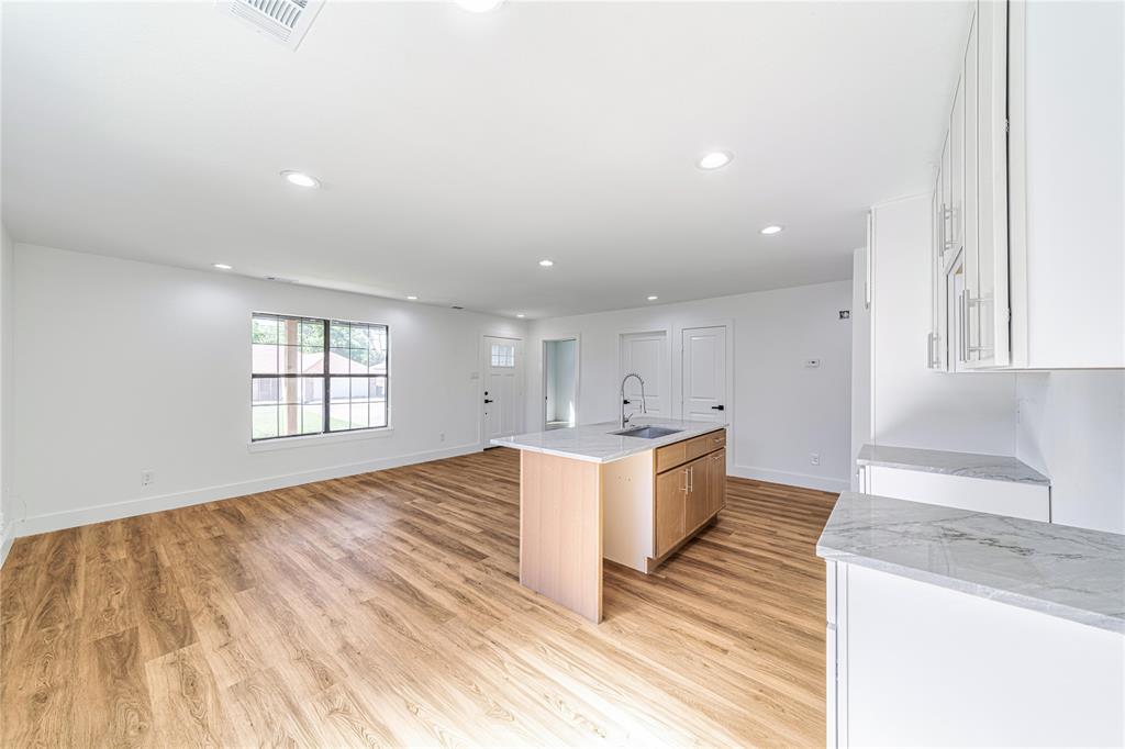 403 Melody Circle Kaufman, TX 75142 - Photo 7 of 25 a large kitchen with stainless steel appliances kitchen island a large counter top and a wooden floors