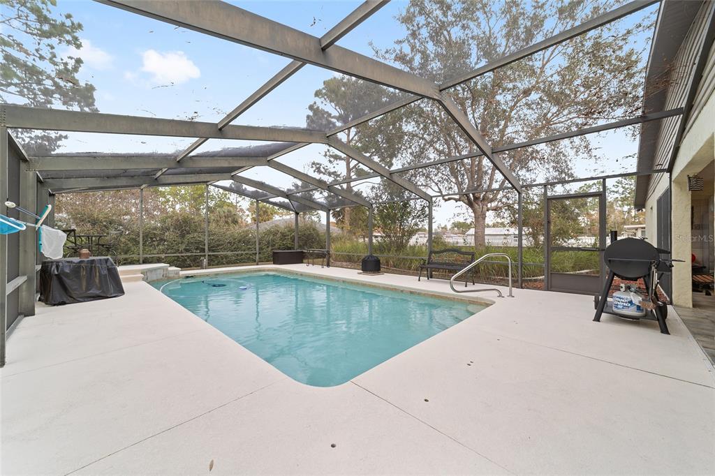 3 Fir Trail Ocala, FL 34472 - Photo 15 of 74 a view of a swimming pool with a bench in patio
