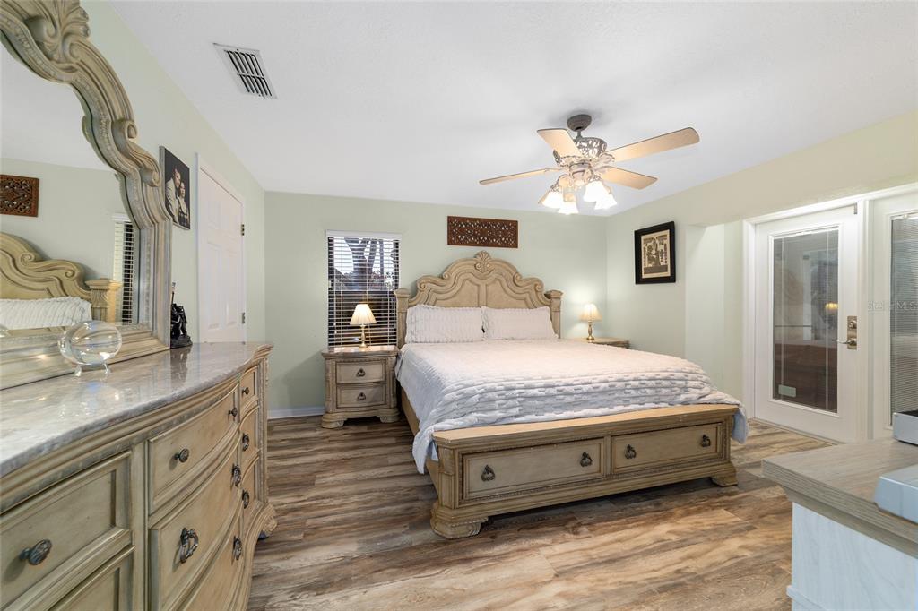 3 Fir Trail Ocala, FL 34472 - Photo 40 of 74 a spacious bedroom with a bed and a chandelier