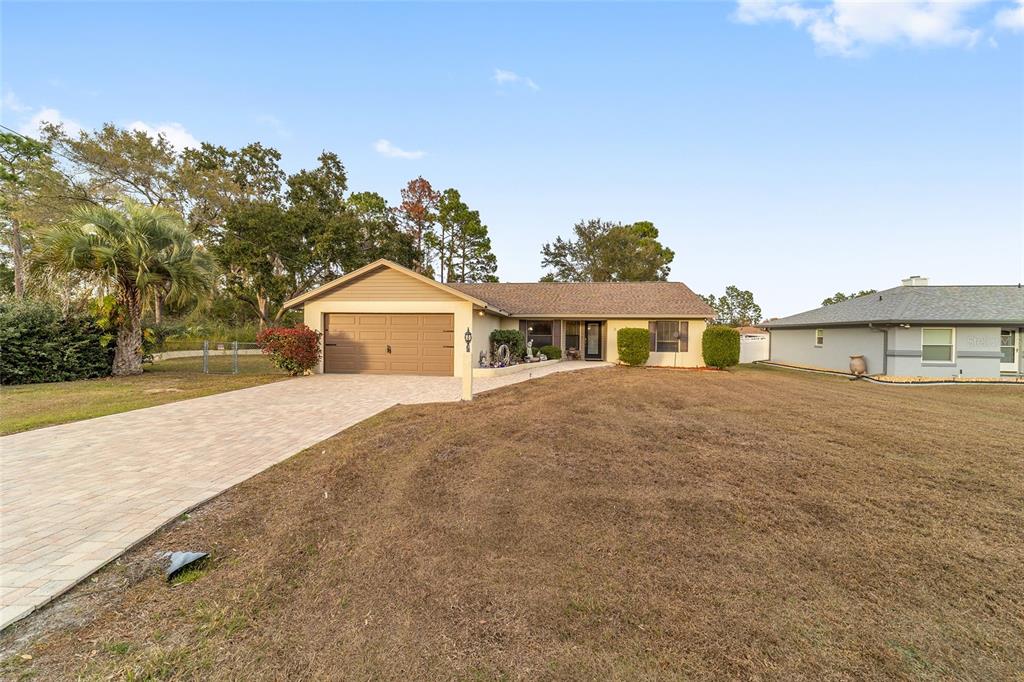 3 Fir Trail Ocala, FL 34472 - Photo 70 of 74 a front view of a house with a yard and garage