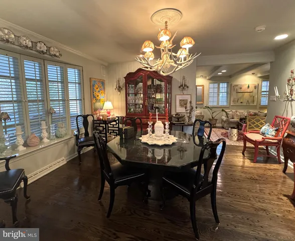 a view of a dining room with furniture a chandelier and large windows