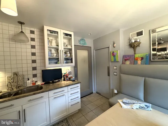 a kitchen with stainless steel appliances kitchen island granite countertop a refrigerator and a sink