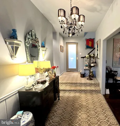 a living room with furniture flowerpot and a chandelier