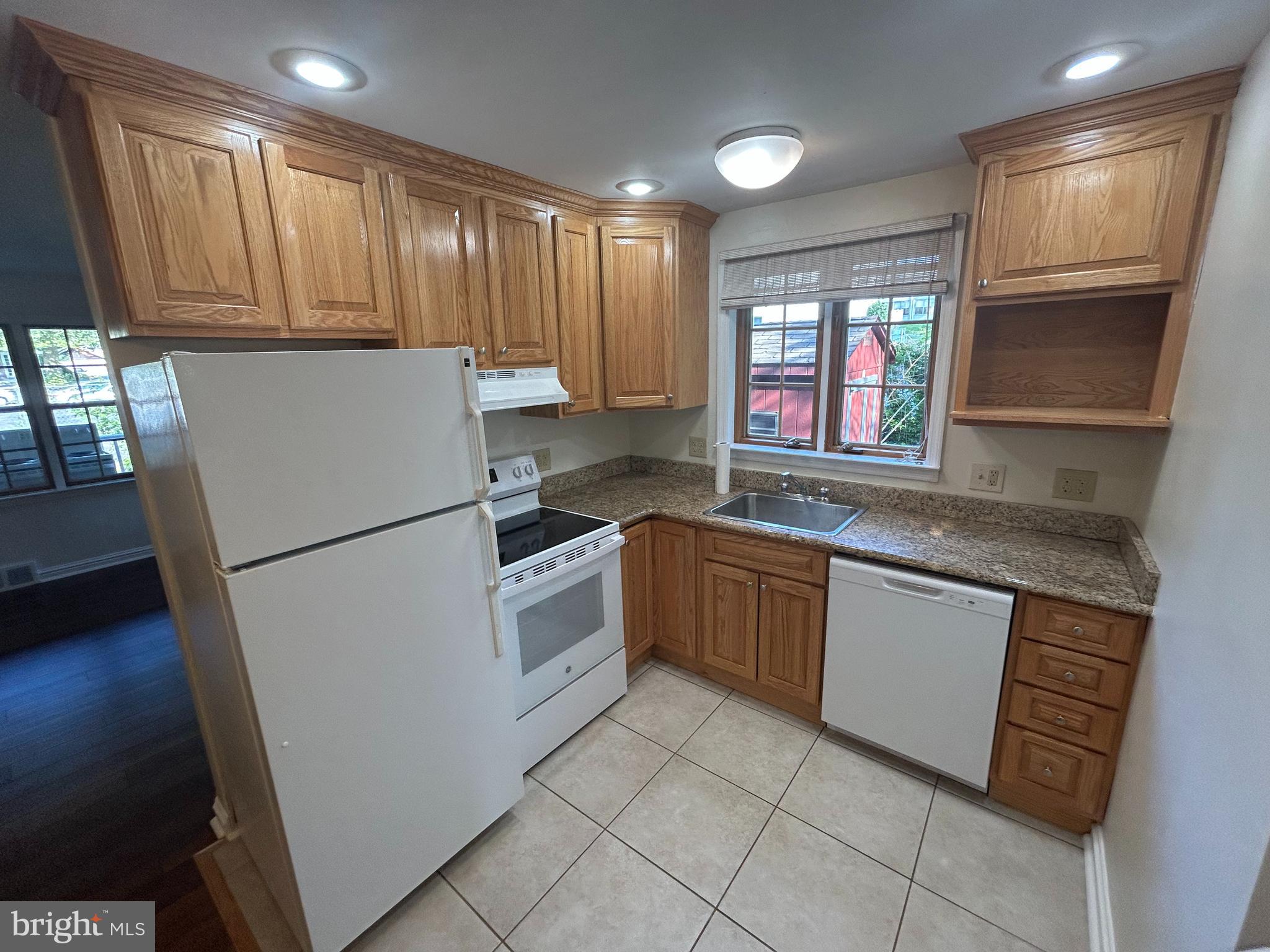 214 Grayling Avenue, Unit ONE Narberth, PA 19072 - Photo 8 of 22 a kitchen with granite countertop appliances a sink and a refrigerator