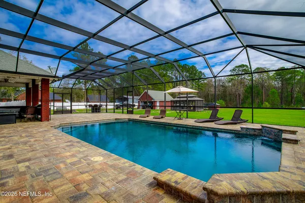 a view of a backyard with table and chairs under an umbrella