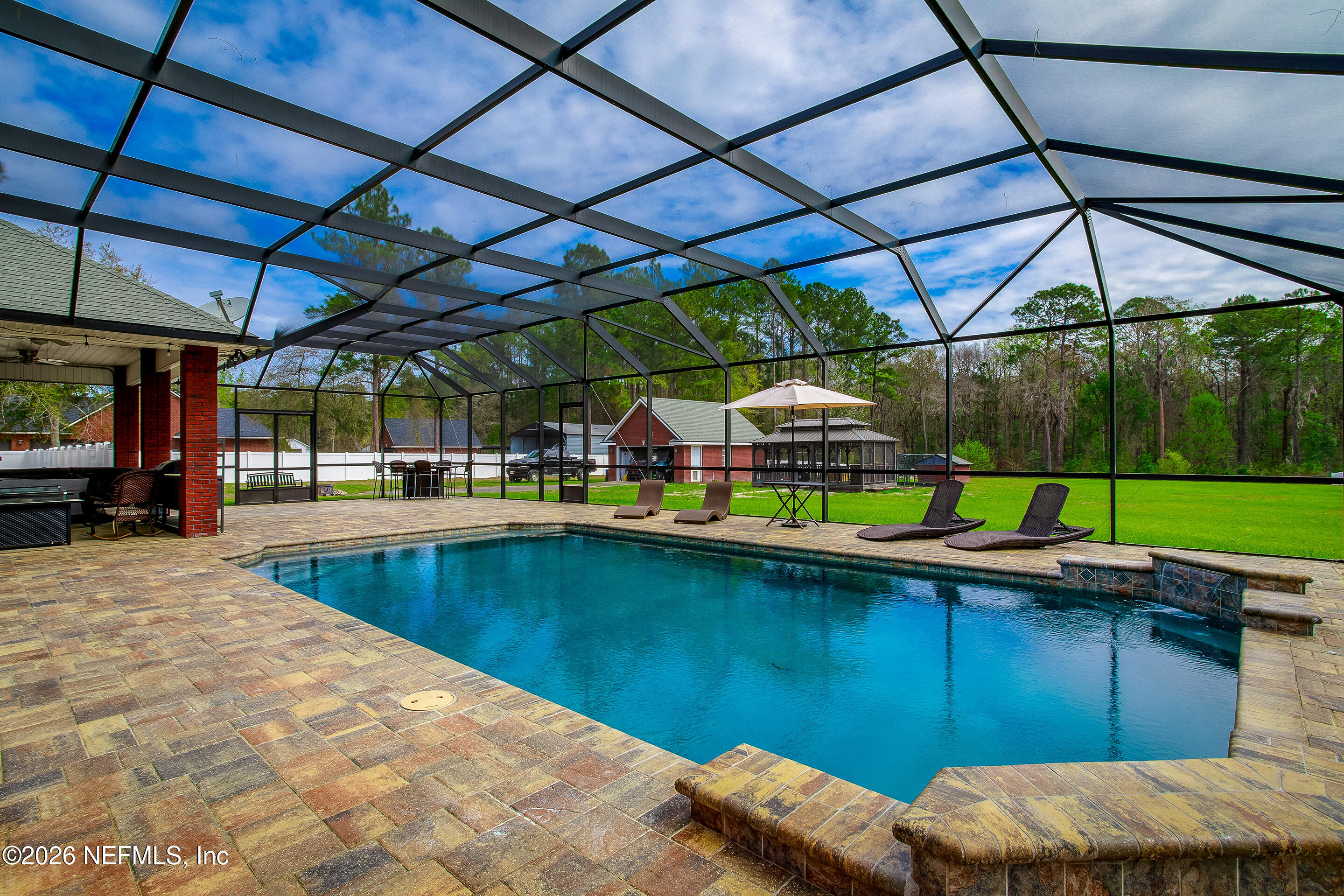 3795 Raintree Drive Macclenny, FL 32063 - Photo 22 of 40 a view of a backyard with table and chairs under an umbrella