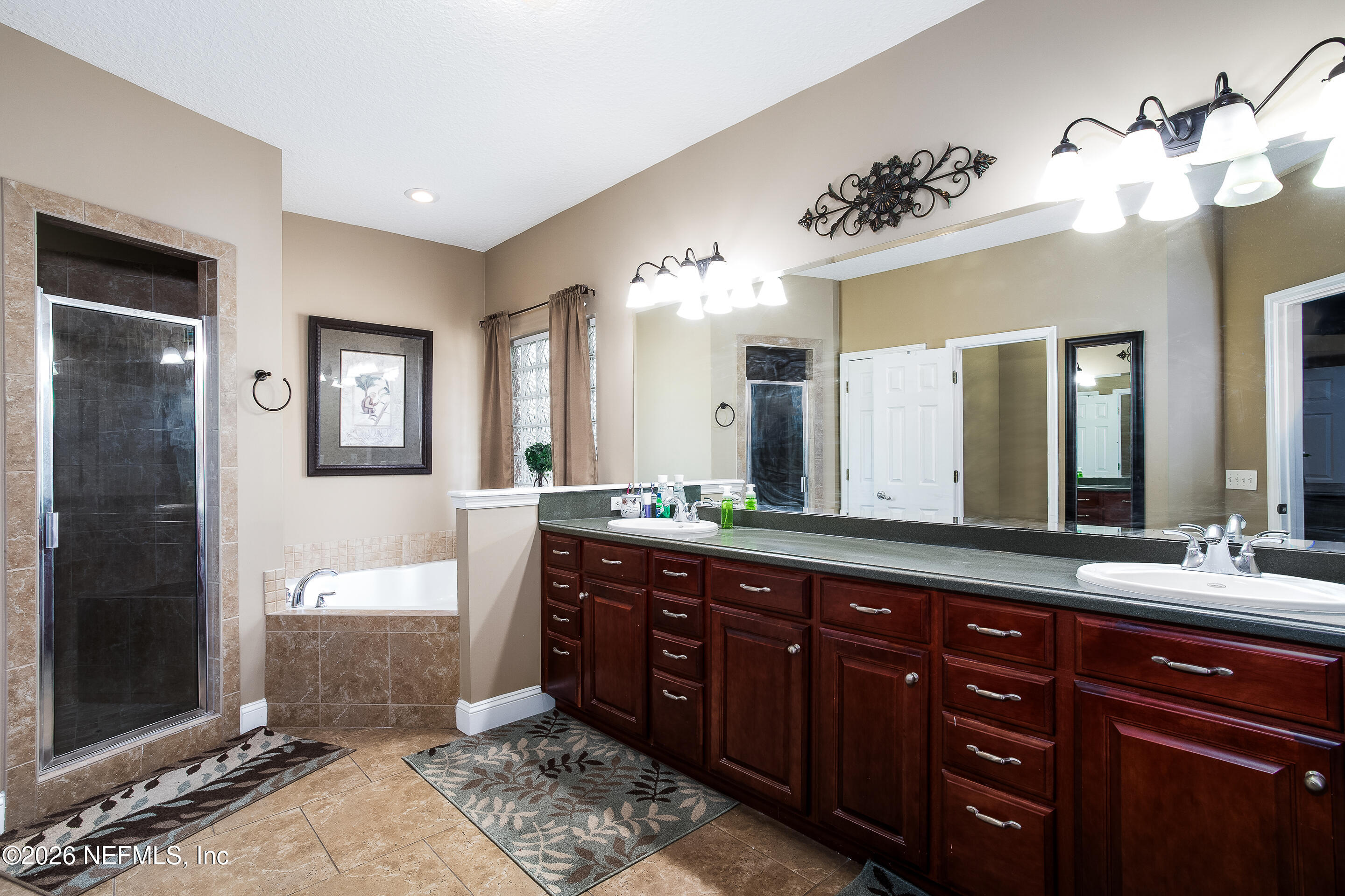 3795 Raintree Drive Macclenny, FL 32063 - Photo 10 of 40 a spacious bathroom with a granite countertop double vanity sink a mirror and a shower