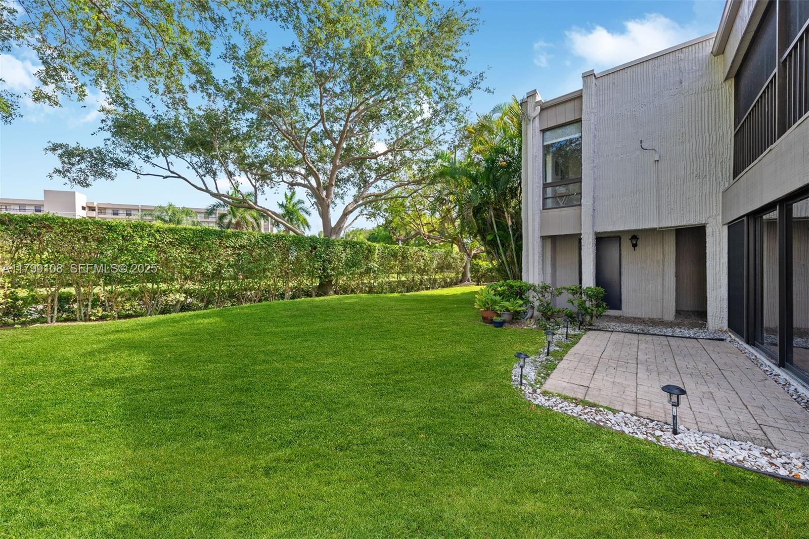 6668 Burning Wood Drive, Unit 166 Boca Raton, FL 33433 - Photo 12 of 27 a view of backyard with potted plants and large tree