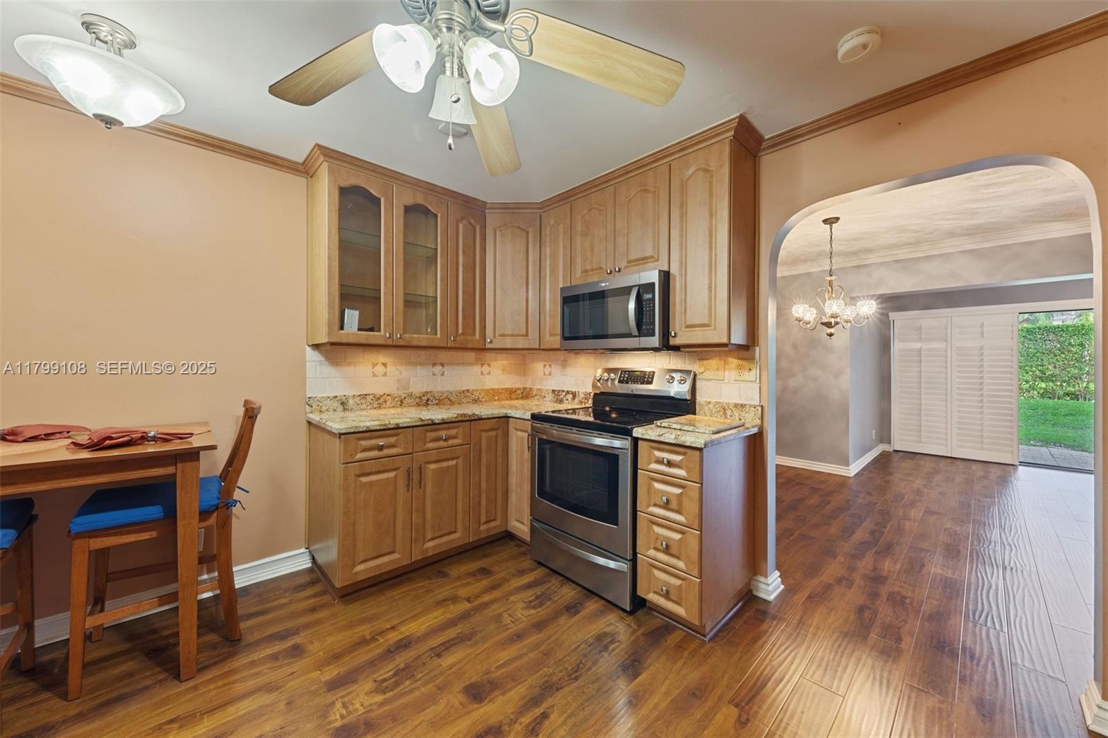 6668 Burning Wood Drive, Unit 166 Boca Raton, FL 33433 - Photo 14 of 27 a kitchen with granite countertop wooden floors appliances and cabinets