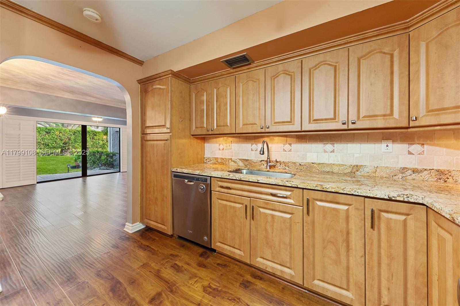 6668 Burning Wood Drive, Unit 166 Boca Raton, FL 33433 - Photo 15 of 27 a kitchen with granite countertop wooden cabinets a sink and dishwasher a stove with wooden floor