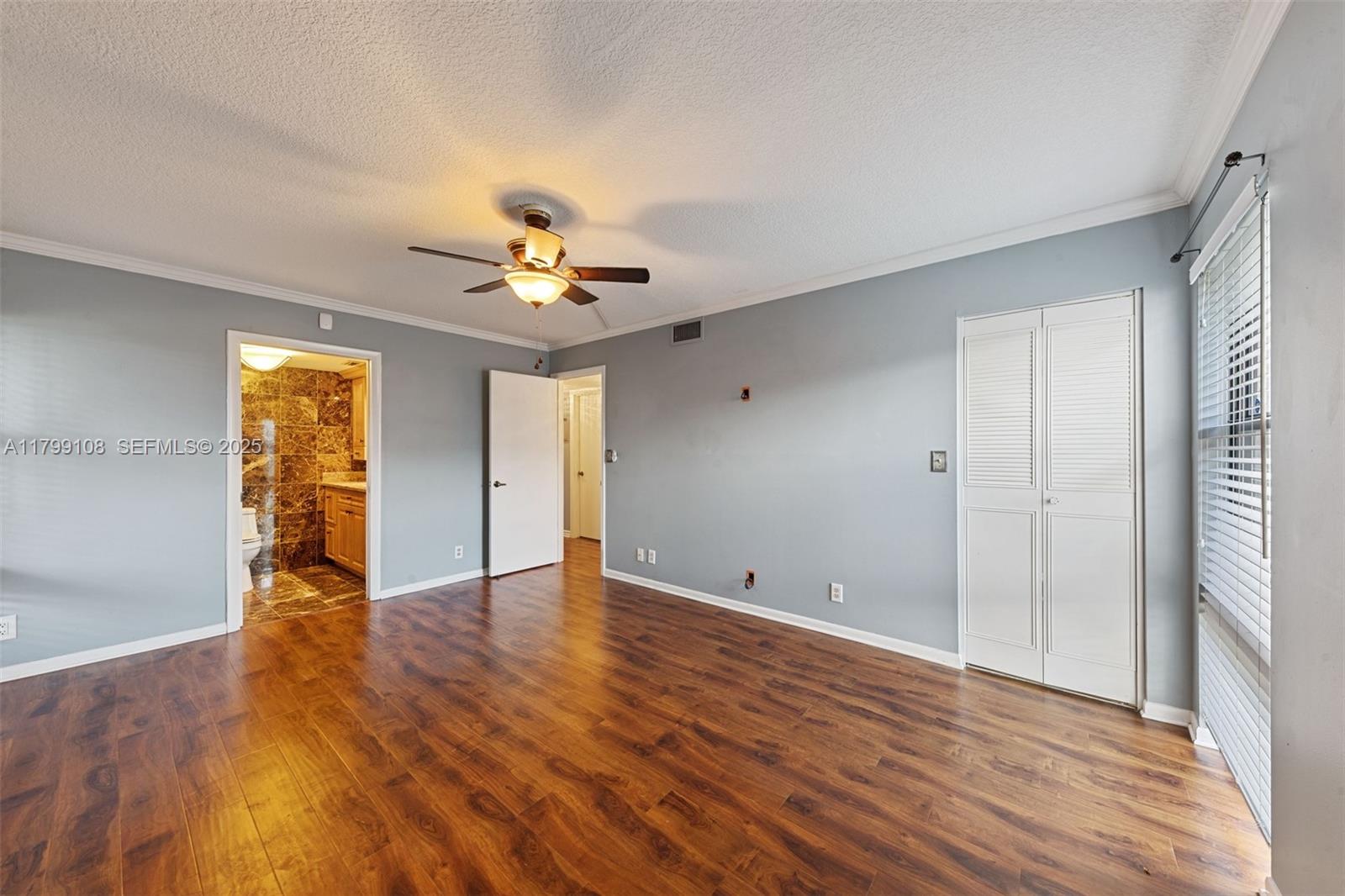 6668 Burning Wood Drive, Unit 166 Boca Raton, FL 33433 - Photo 18 of 27 a view of an empty room with window and wooden floor