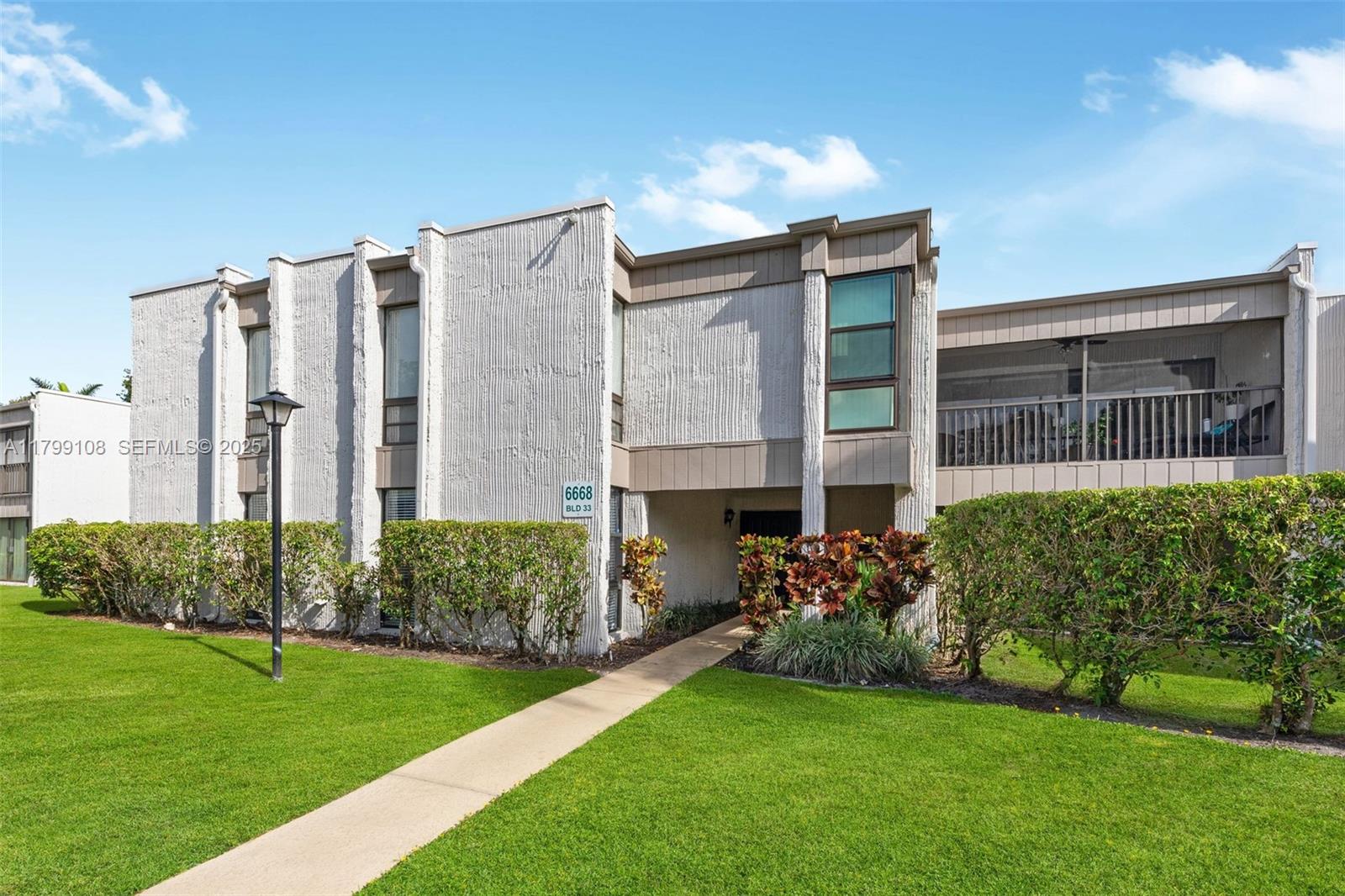6668 Burning Wood Drive, Unit 166 Boca Raton, FL 33433 - Photo 2 of 27 a front view of a house with a yard