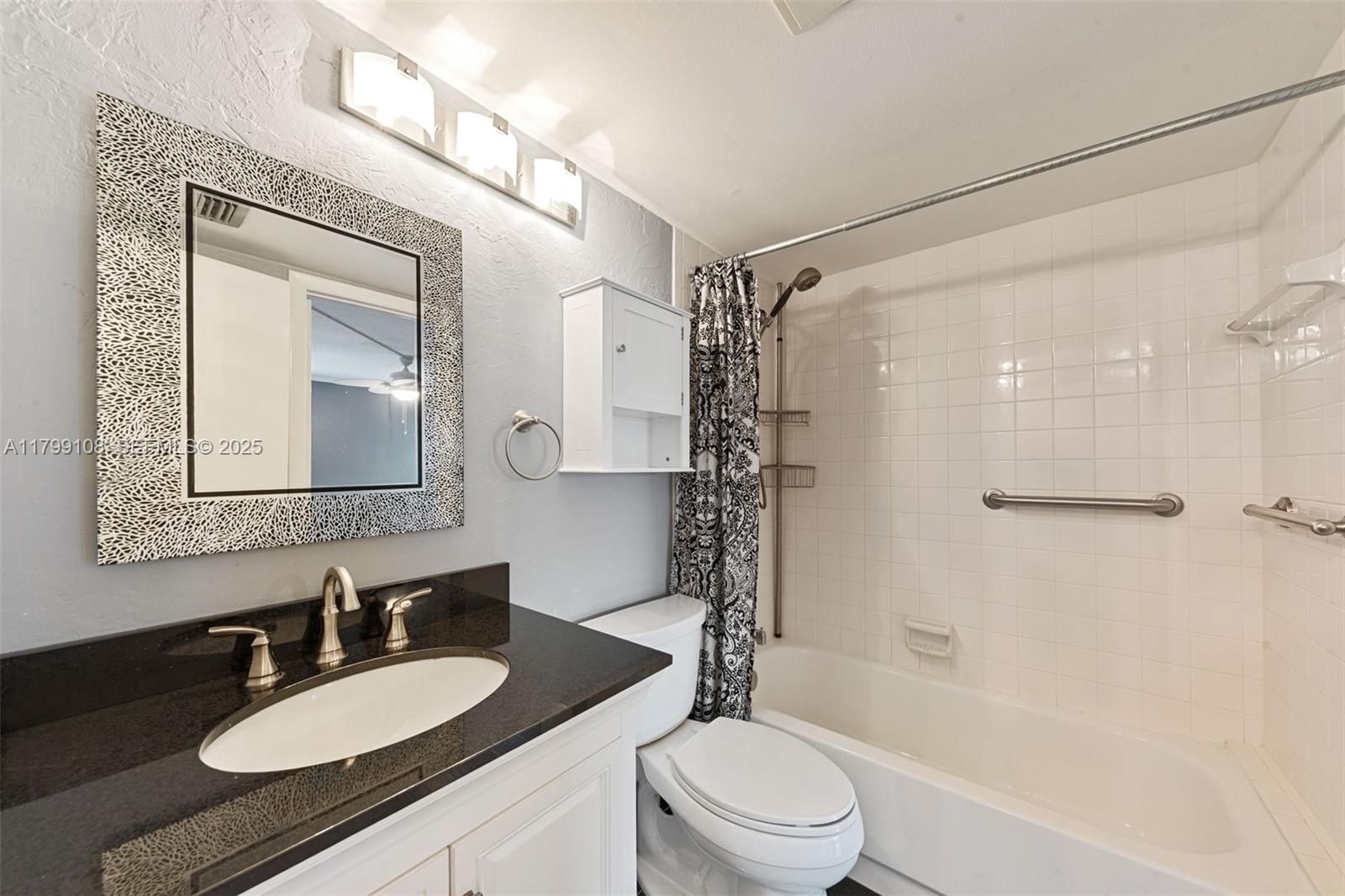 6668 Burning Wood Drive, Unit 166 Boca Raton, FL 33433 - Photo 25 of 27 a bathroom with a granite countertop sink toilet mirror and shower