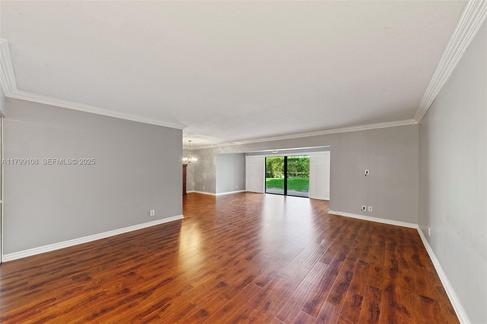 6668 Burning Wood Drive, Unit 166 Boca Raton, FL 33433 - Photo 5 of 27 an empty room with wooden floor and windows