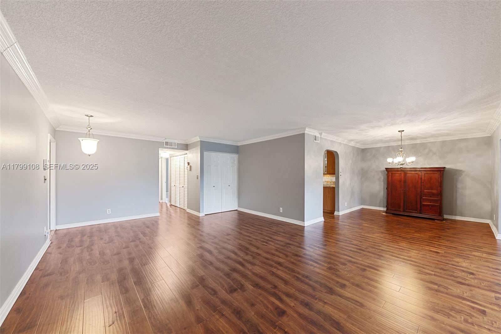 6668 Burning Wood Drive, Unit 166 Boca Raton, FL 33433 - Photo 6 of 27 a view of an empty room with wooden floor and kitchen