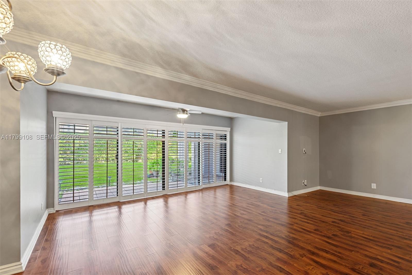 6668 Burning Wood Drive, Unit 166 Boca Raton, FL 33433 - Photo 9 of 27 a view of an empty room with wooden floor and a window