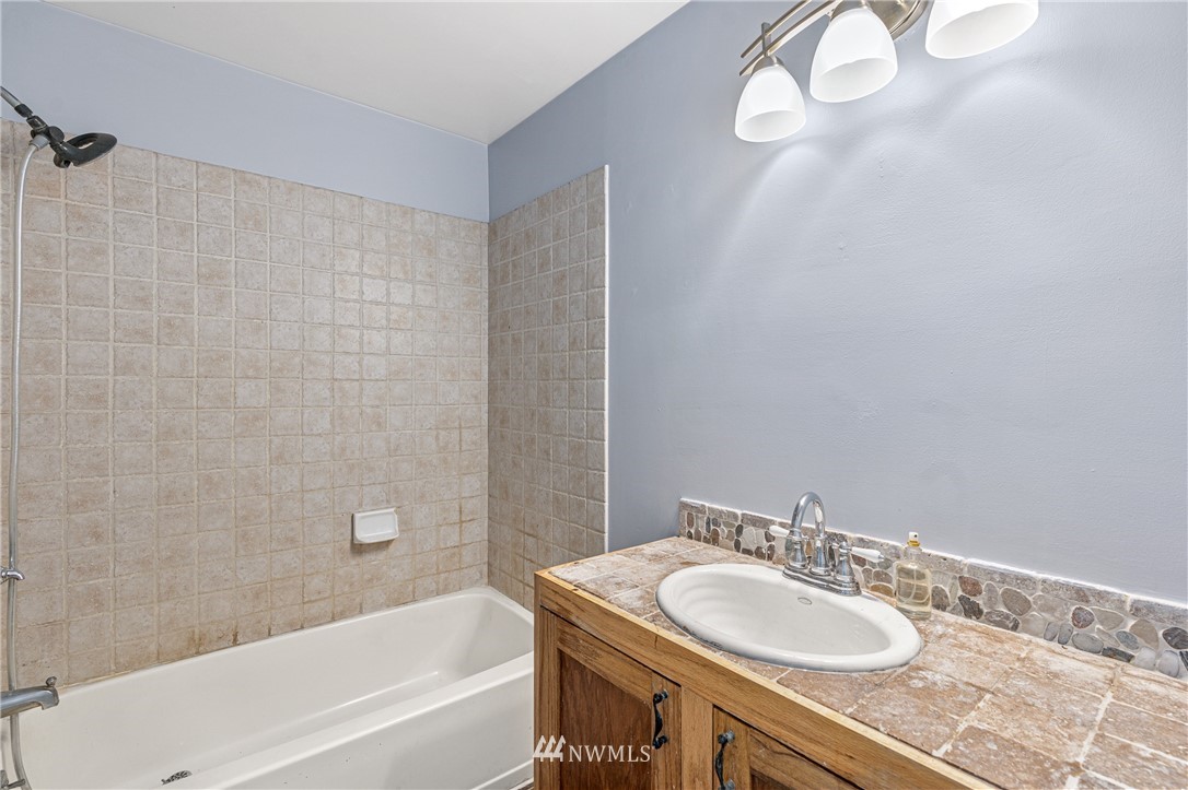 929 Blackburn Road Camano Island, WA 98282 - Photo 28 of 39 a bathroom with a granite countertop sink and a mirror